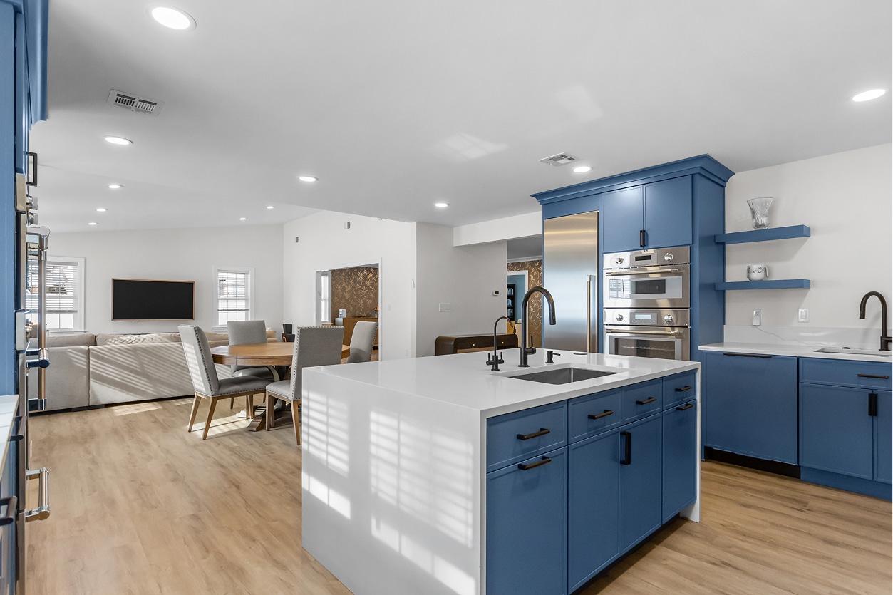 a blue kitchen with dining room space in a new addition to a home