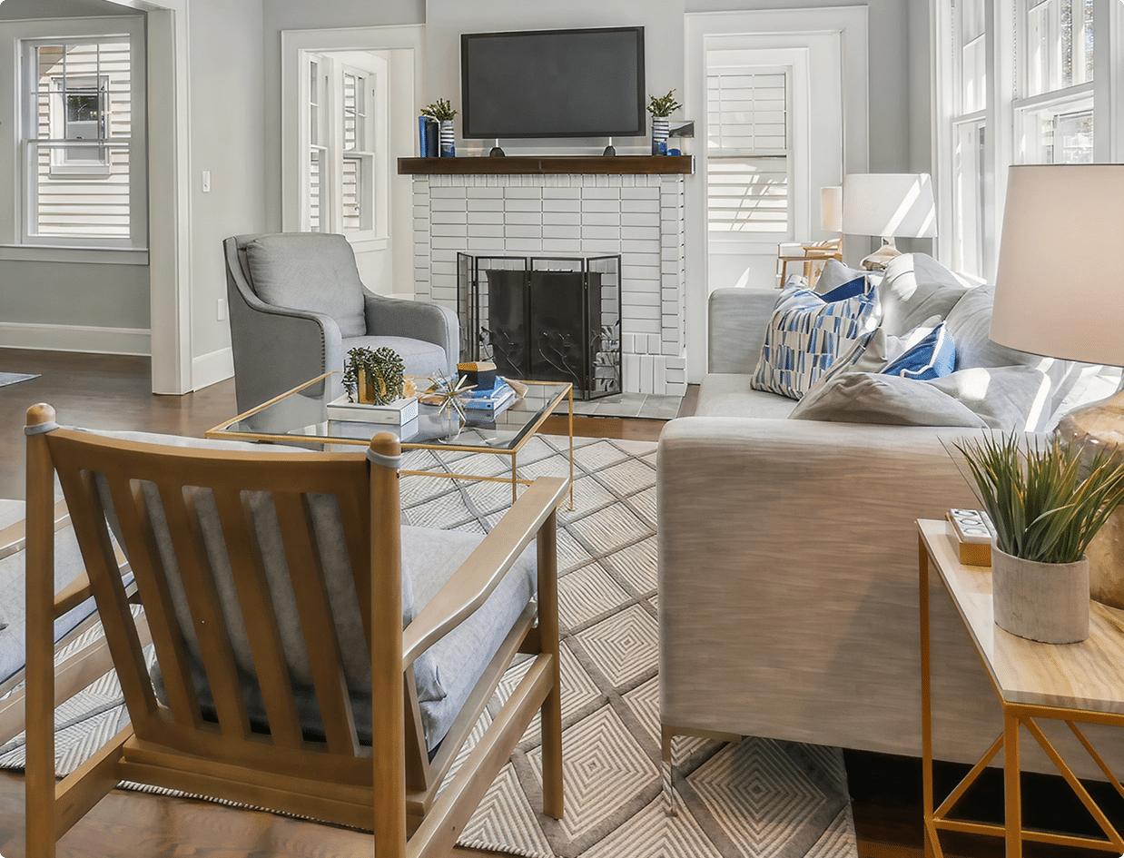 a modern renovated living room with a fireplace and chairs