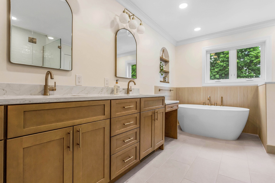 master bathroom with white tub and wooden cabinets